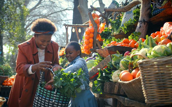 mother and daughter shopping at vegetable cart